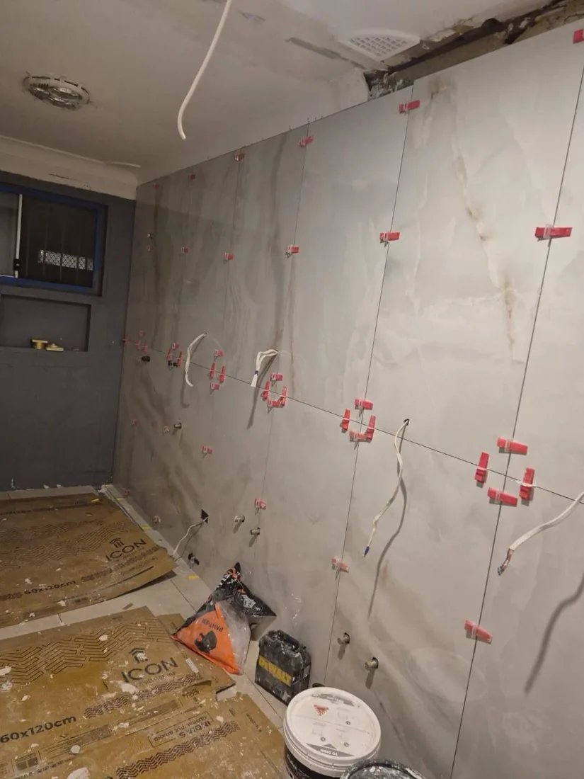Large-format marble-look wall tiles being installed