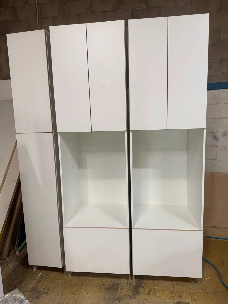Custom white laundry cabinets assembled before installation