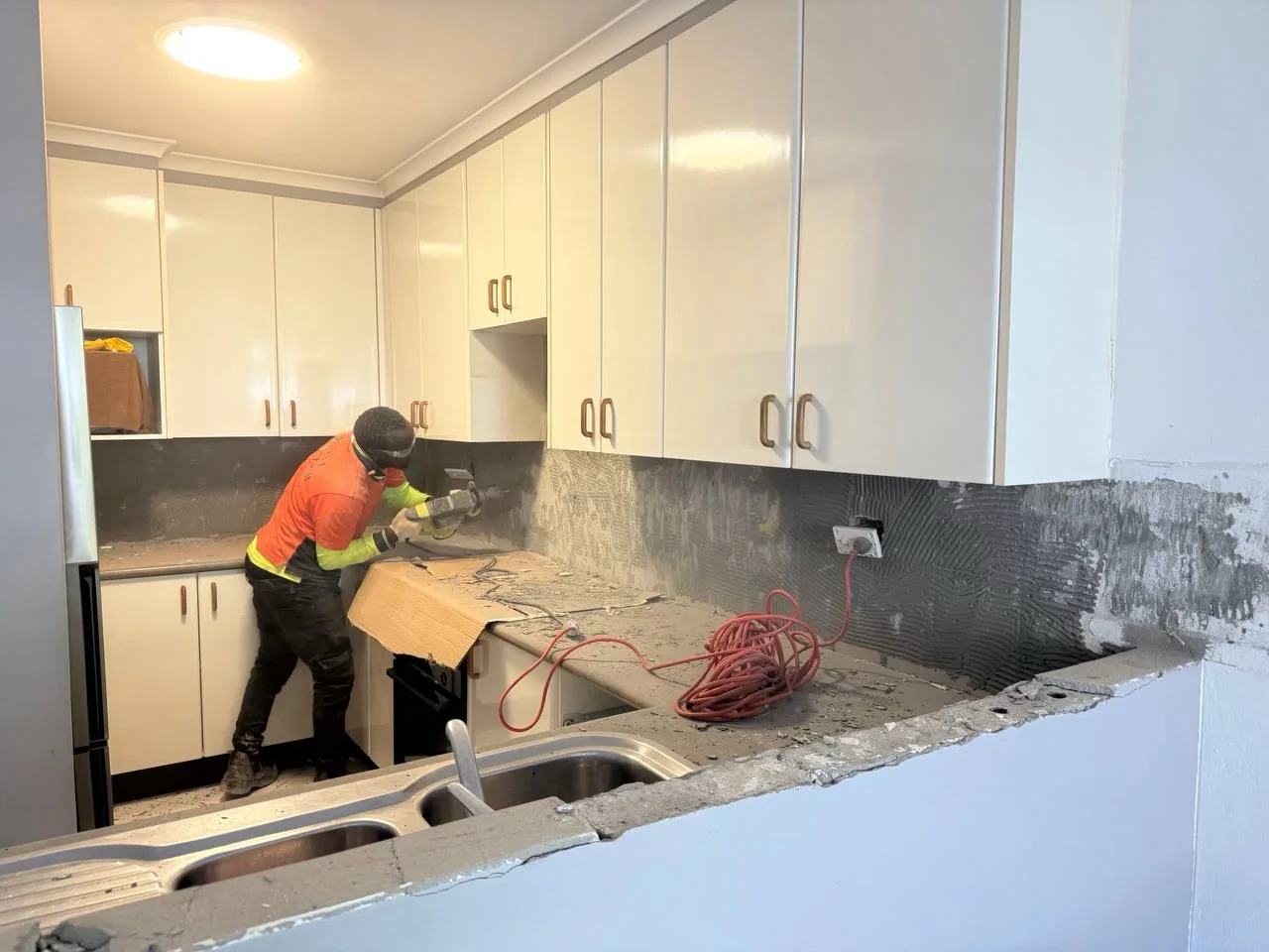 Rosebery kitchen splashback removal in progress with tradesperson at work
