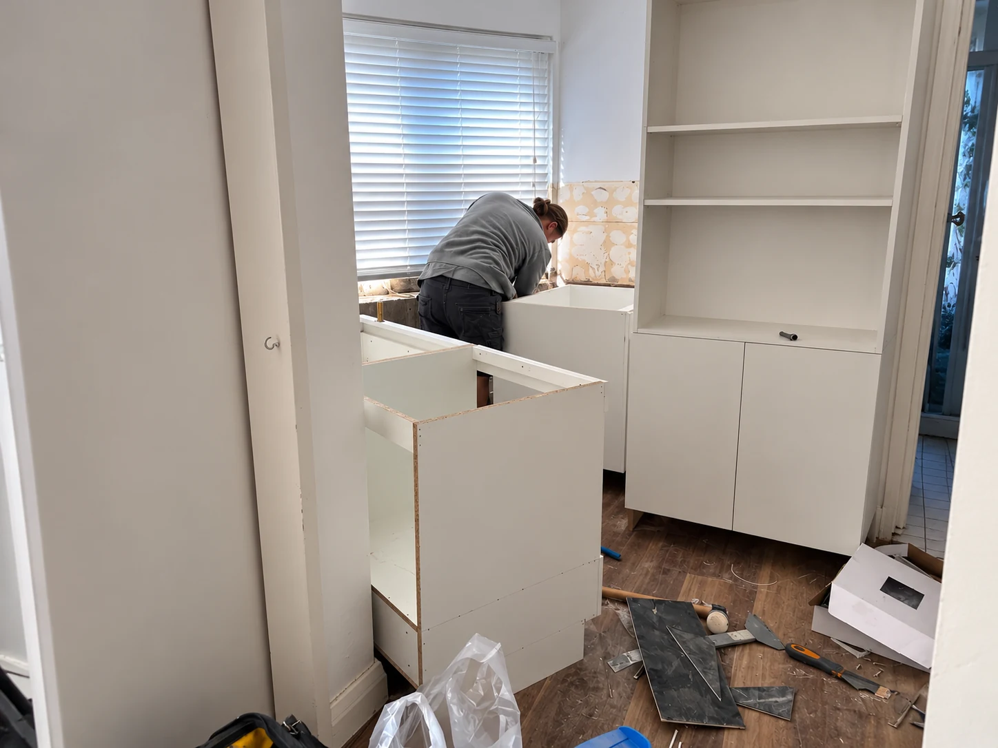Tradesperson installing kitchen cabinetry in the studio